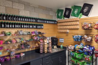 Picture of the student store. Snacks and merchandise displayed on the walls and counter top.